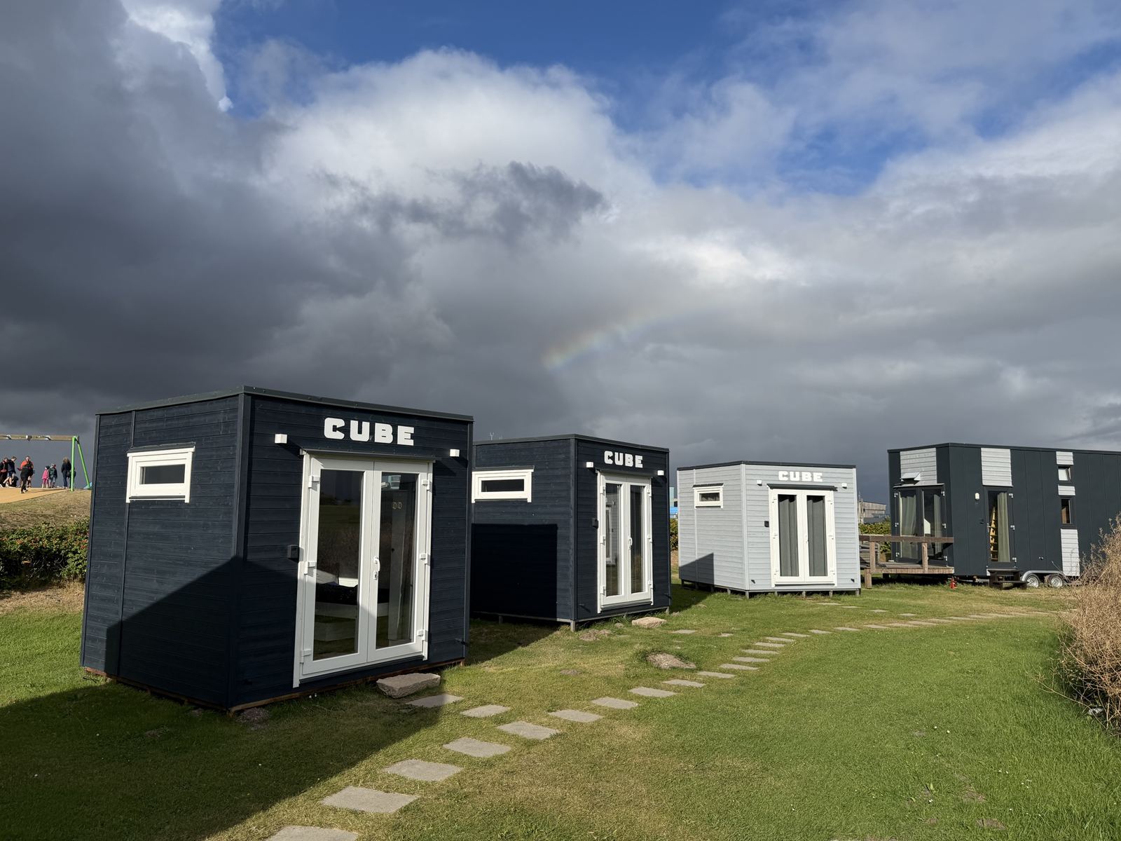Bensersiel: drei Cubes und das Tiny House in einer Reihe unter Wolken
